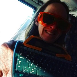 Wearing bluelight glasses over sunglasses and holding an AlphaSmart